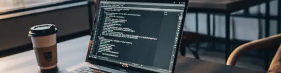 Die Arbeitsumgebung eines Webentwicklers - Laptop auf Schreibtisch im Büro