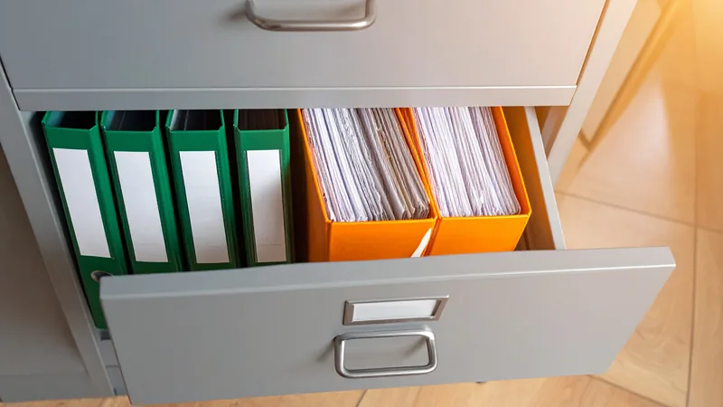 Schublade mit grünen Ordnern und fremden orangen Stehsammlern – Erzeuger von SEO-Spam in einem Unterordner